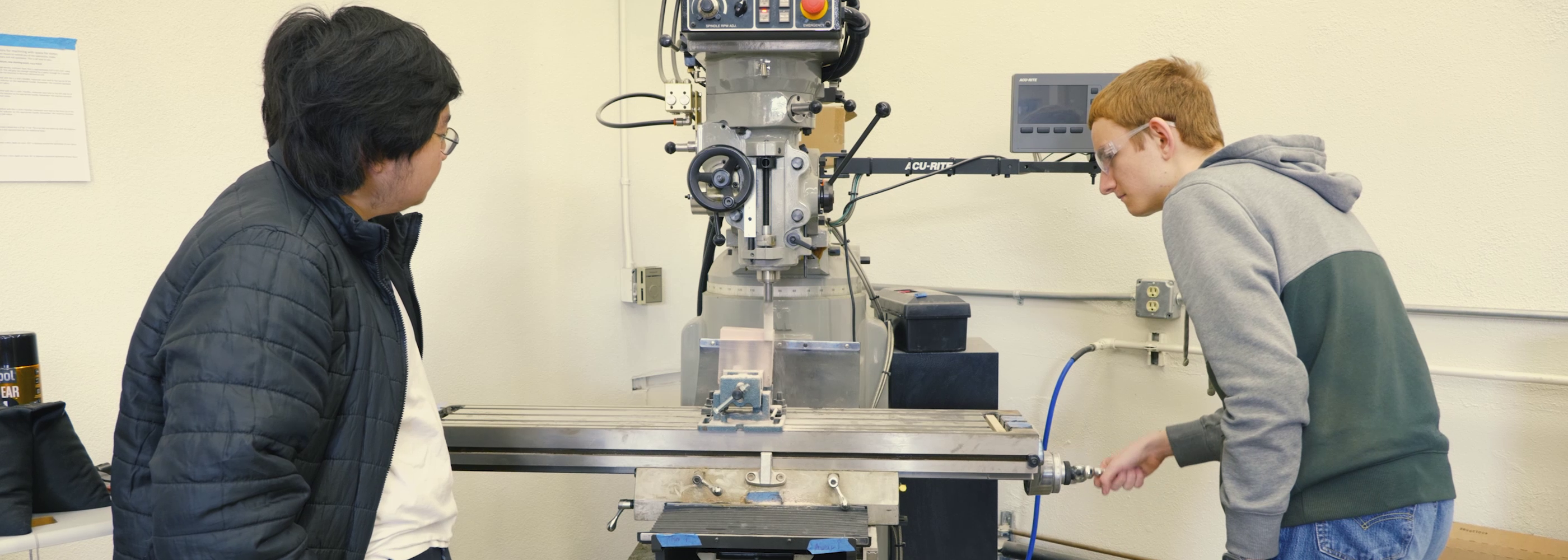 students using a machine to cut wood